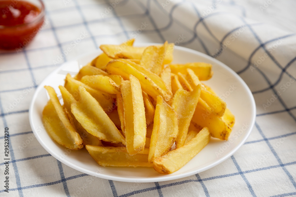 Homemade french fries with sour-sweet sauce on a white plate, low angle view. Closeup. Homemade french fries with sour-sweet sauce on a white plate, low angle view. Closeup.