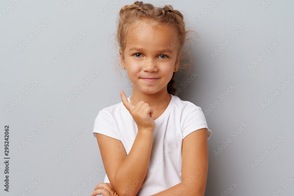 Image of thinking little girl standing over a gray background Image of thinking little girl standing over a gray background