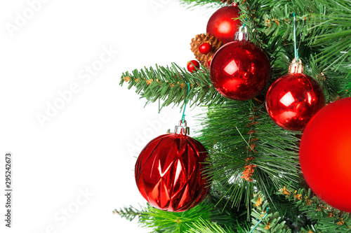 Spruce branches with red baubles against white background