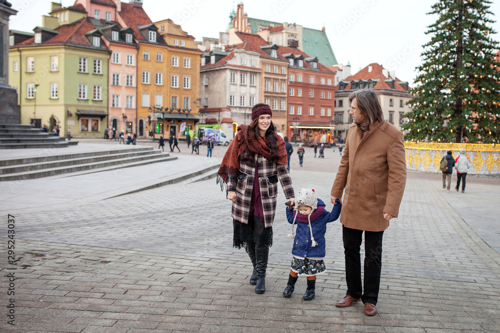 Happy Family - mother, father and little girl walking in autumn city and having fun