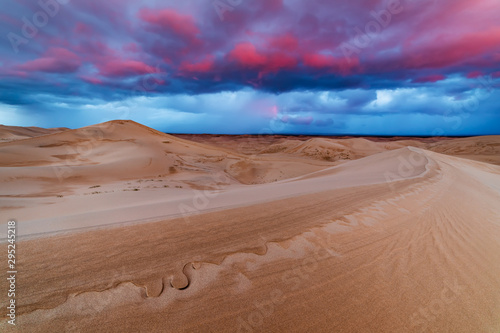 Dramatic sunset over sand dunes in the desert
