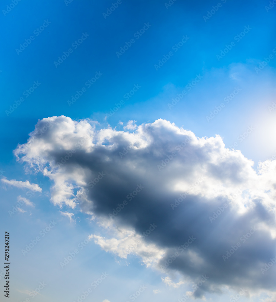 Beautiful puffy clouds with sun beams against blue skies.  