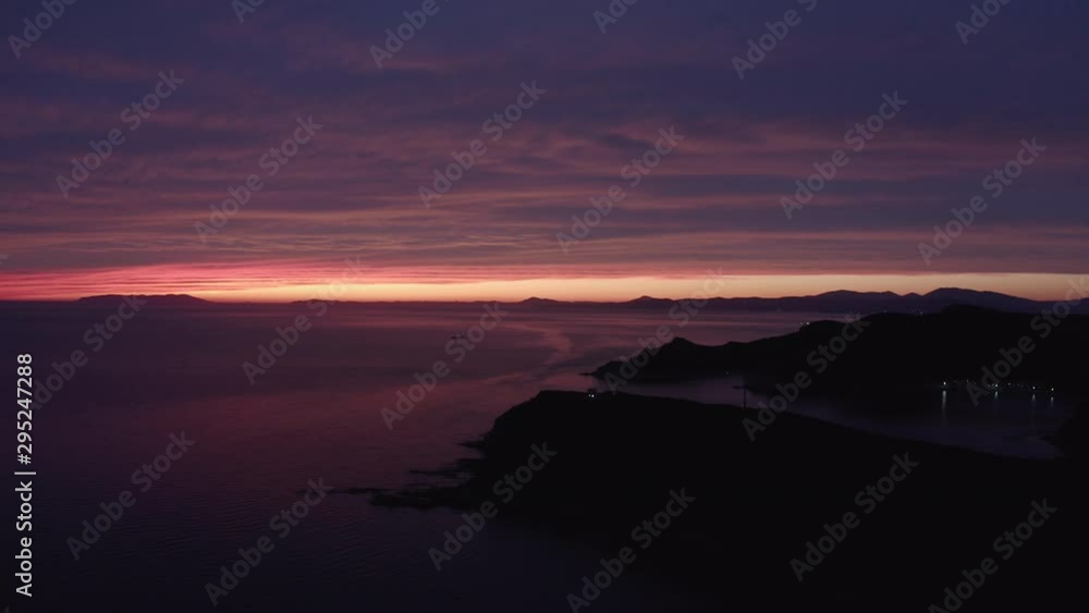Epic colorful sunset with a narrow stripe of clear sky at the very far distance and various hues of red color reflected on the big cloud and sea surface. Aerial shot, side movement Epic colorful sunset with a narrow stripe of clear sky at the very far distance and various hues of red color reflected on the big cloud and sea surface. Aerial shot, side movement