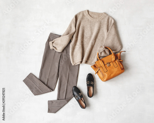 Cuadro en lienzo Brown pants in check, beige knitted oversize sweater, bag, black loafers or flat shoes on grey background