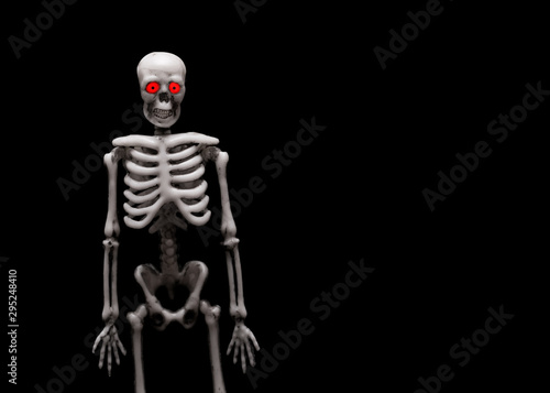 The figure of the human skeleton. Skeleton with red eyes on a black background.