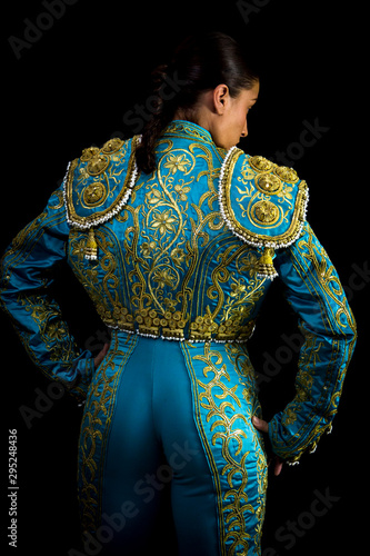 Woman bullfighter suit with blue lights on a black background