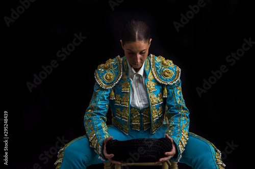 Woman bullfighter sitting on a chair looking at his montera concentrated
