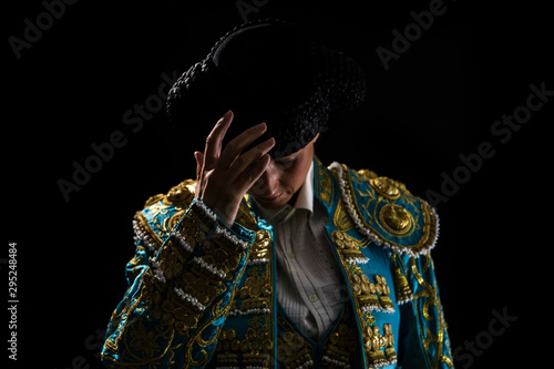 Tableau sur toile Woman bullfighter salutes with his montera in black background