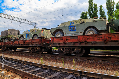 Cargo train carrying military vehicles on railway flat wagons