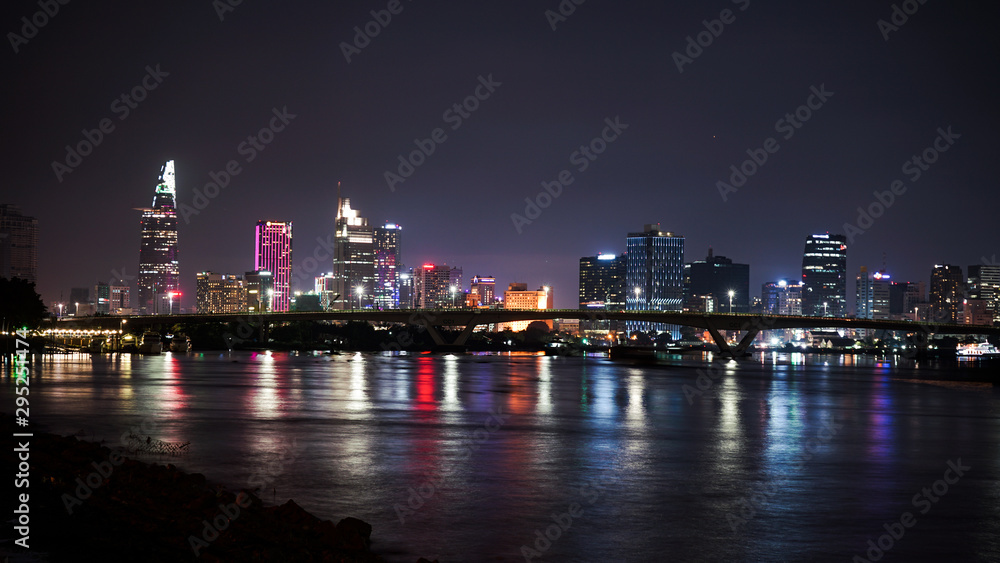 Ho Chi Minh city night view at the bridge, river and skyscrapers. Saigon night life.Big city lights.