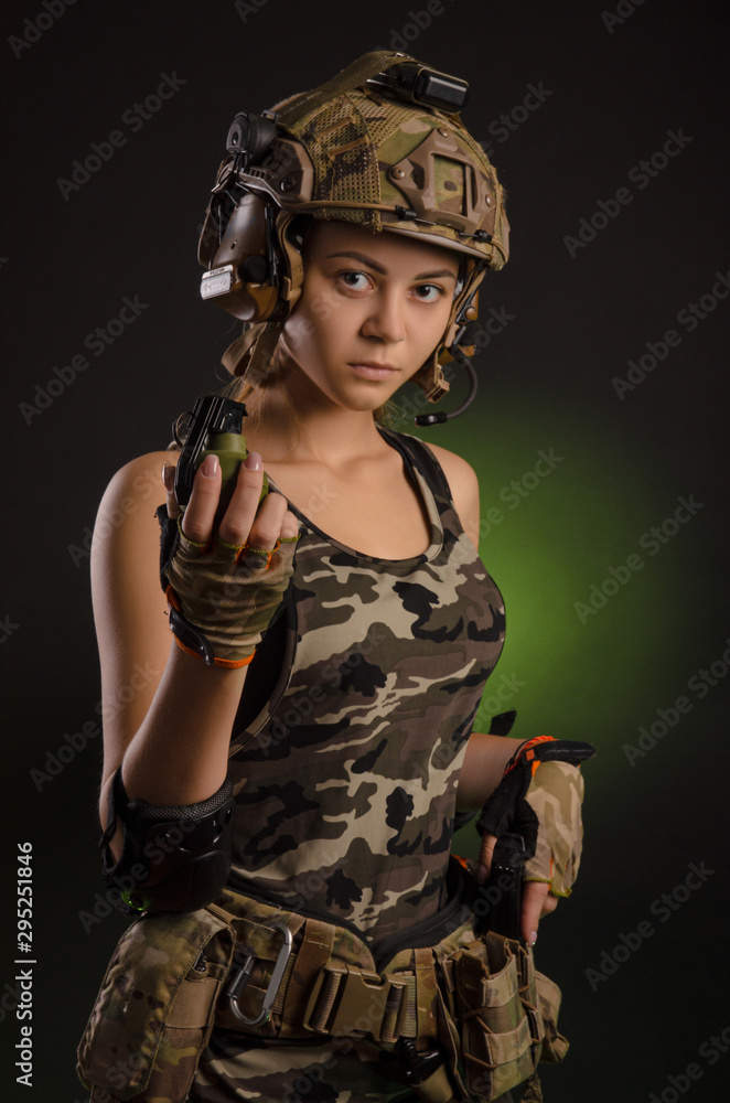 girl in military uniform and helmet holding a grenade girl in military uniform and helmet holding a grenade