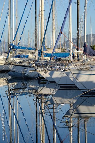 sailboats anchored in the port of Alghero and their reflections on the water