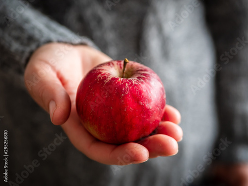 Frau über 40 mit einem roten Apfel in ihrer Hand, Nahaufnahem, Winter