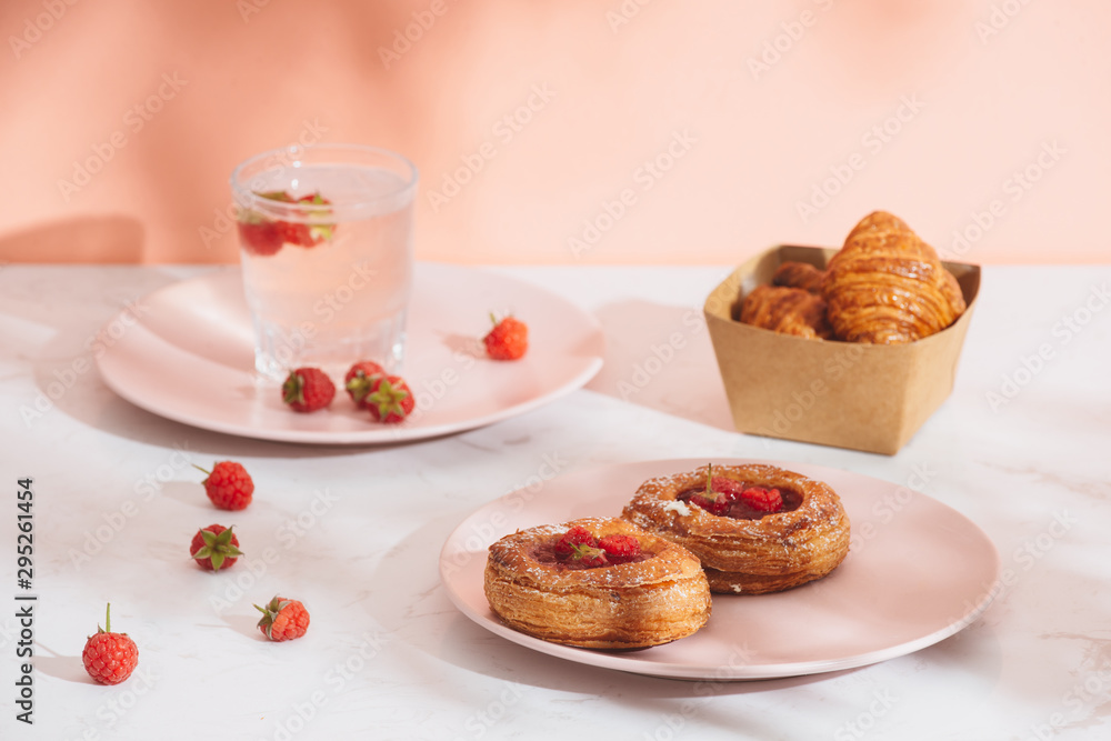 Sweet summer dessert, homemade baked mini croissants, served with cold raspberry cider, fresh raspberries. On a white marble table, copy space top view Sweet summer dessert, homemade baked mini croissants, served with cold raspberry cider, fresh raspberries. On a white marble table, copy space top view