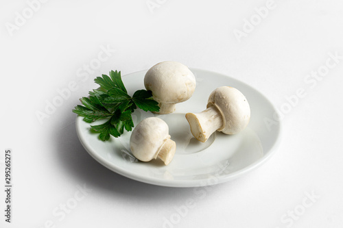 Heap of champignons on plate isolated on white background. Sliced mushrooms top view