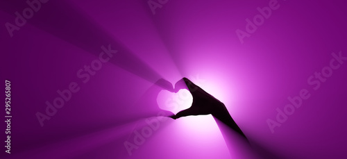 Hand gesture. Symbol of love. Purple spotlight in the background.