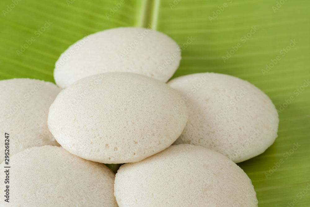 Fresh Indian idly - Fresh steamed Indian Idly (Idli / rice cake) arranged decoratively on traditional banana leaf. Natural light used. Fresh Indian idly - Fresh steamed Indian Idly (Idli / rice cake) arranged decoratively on traditional banana leaf. Natural light used.