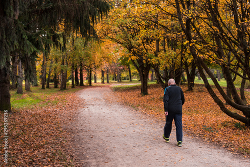 un homme âgé faisant de la marche sportive pour son cœur dans un parc en automne 