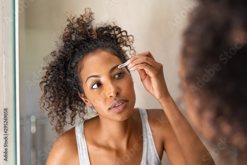 Obraz na plátne African woman plucking eyebrows