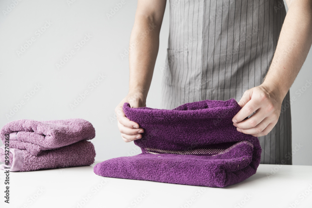 Front view person folding towels Front view person folding towels