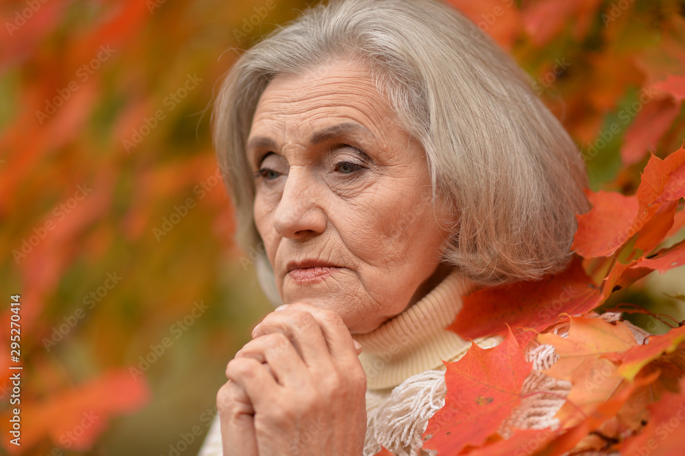 Portrait of sad senior woman in autumn park Portrait of sad senior woman in autumn park