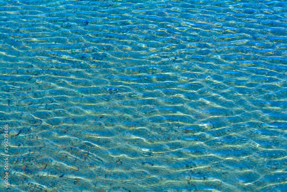 Ripples on the surface of the water with sun glare. Blue water. Ripples on the surface of the water with sun glare. Blue water.