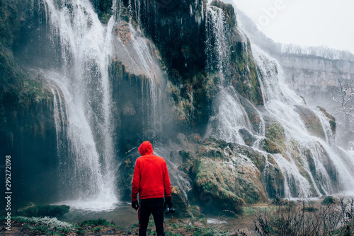 un homme visitant une cascade gelée dans le jura