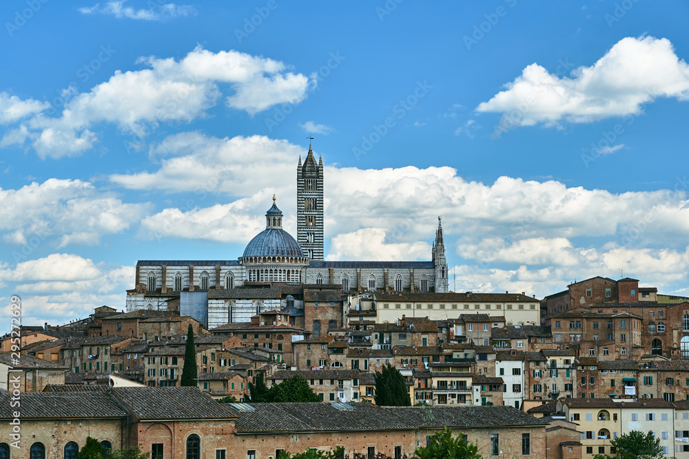 Historic houses and bell tower and dome of the medieval cathedral in Siena, Italy.