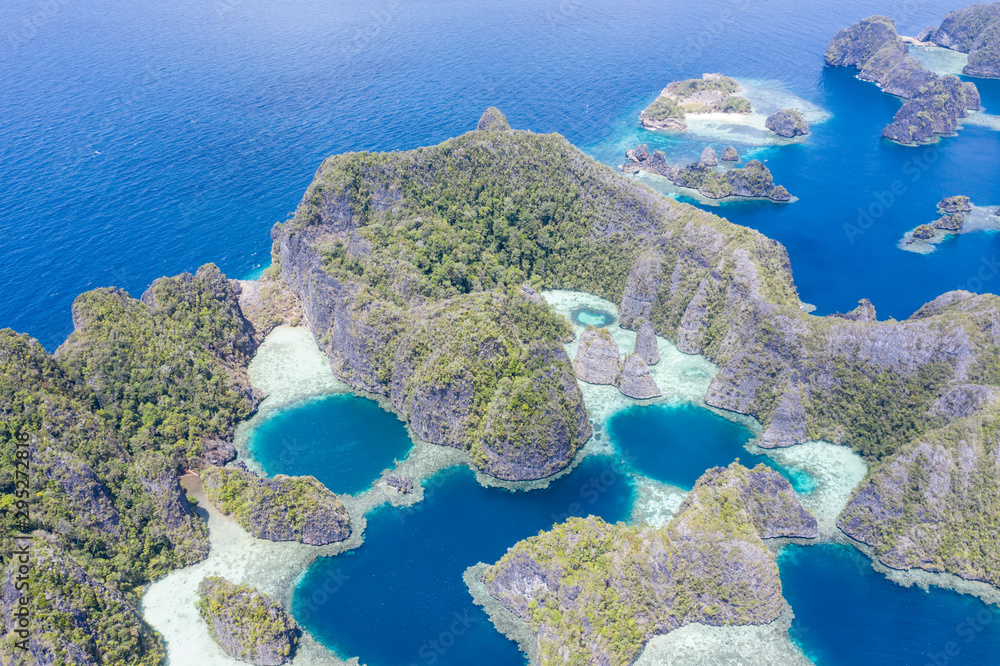 Fringing coral reefs thrive along the edge of the beautiful limestone islands found near Misool, Raja Ampat, Indonesia. This tropical area is known for its incredible marine biodiversity.
