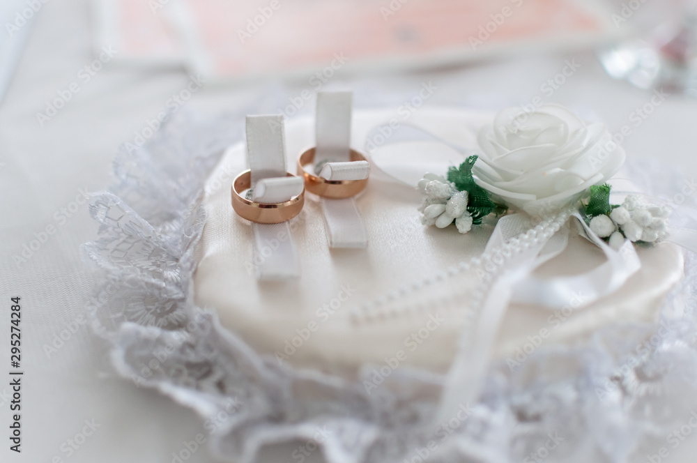 Couple of gold wedding rings on the white pad Couple of gold wedding rings on the white pad