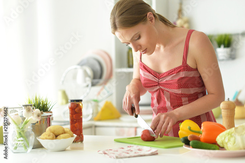 Portrait of young woman cooking in kitchen