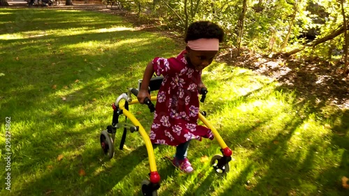 Black girl with Cerebral Palsy walking in the park with her assistive device photo