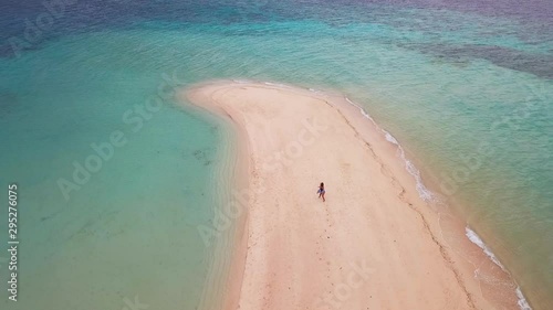 Lonely Girl on Sand Bar Beach in Tropical Paradise Island, Orbit Slow Motion Aerial. Waling Waling Island, Coron Palawan Philippines photo