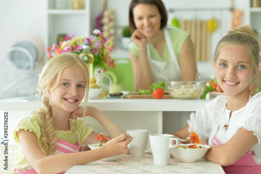 Portrait of girls eating delicious fresh salad in kitchen Portrait of girls eating delicious fresh salad in kitchen