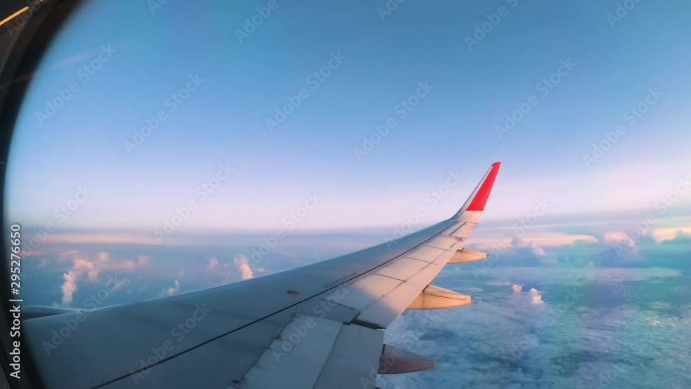 Airplane flight. Wing of an airplane flying above the clouds with sunset sky. View from the window of the plane. Aircraft. Traveling by air. Airplane flight. Wing of an airplane flying above the clouds with sunset sky. View from the window of the plane. Aircraft. Traveling by air.