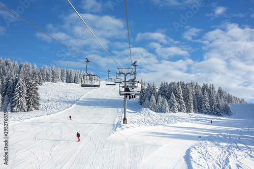 Wintersports fans riding the ski lift to empty pistes.