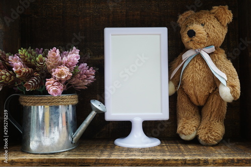 Blank Display frame stand with artificial plant home decoration on wooden background