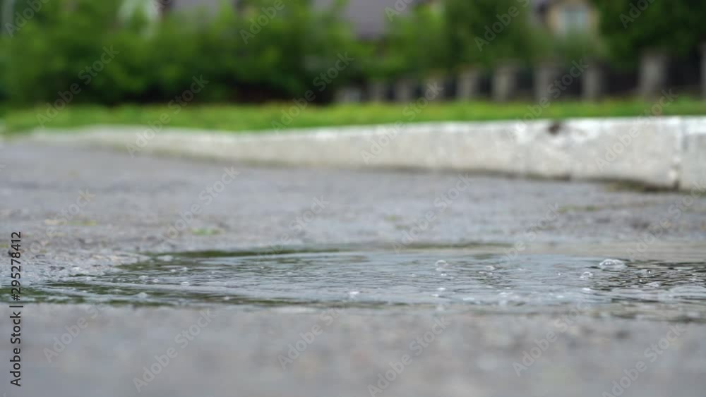 Legs of a runner in sneakers. Sports woman jogging outdoors, stepping into muddy puddle. Single runner running in rain, making splash Legs of a runner in sneakers. Sports woman jogging outdoors, stepping into muddy puddle. Single runner running in rain, making splash