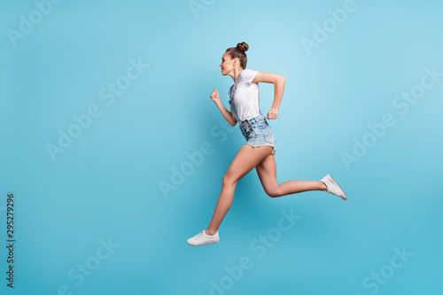 Full length body size photo of running sportive girl aspiring to reach her aim while isolated with blue background