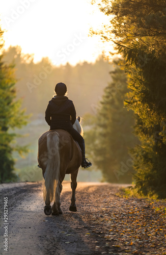 Woman horseback riding in autumn landscape