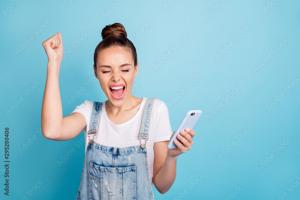 Photo of rejoicing excited overjoyed cheerful girl glad to have won phone funky funny while isolated with blue background Photo of rejoicing excited overjoyed cheerful girl glad to have won phone funky funny while isolated with blue background