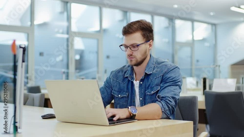 Young man working on a laptop in public library