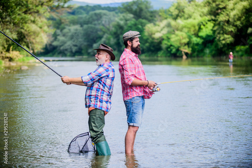 Father and son fishing. Summer weekend. Peaceful activity. Nice catch. Rod and tackle. Fisherman fishing equipment. Fisherman grandpa and mature man friends. Fisherman family. Hobby sport activity