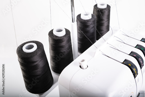 Black thread bobbins on overlock. Sewing machine. photo