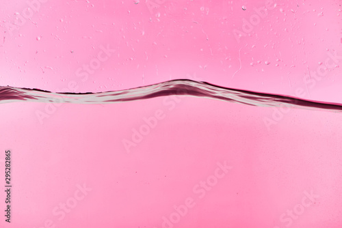 wavy clear fresh water on pink background with drops