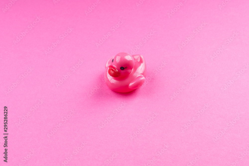 Pink glamour rubber duck with red lips on monochrome background.