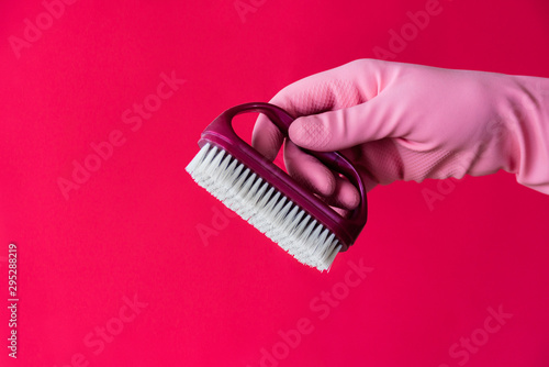 Hand in pink glove with cleaning brush