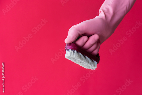 Hand in pink glove with cleaning brush