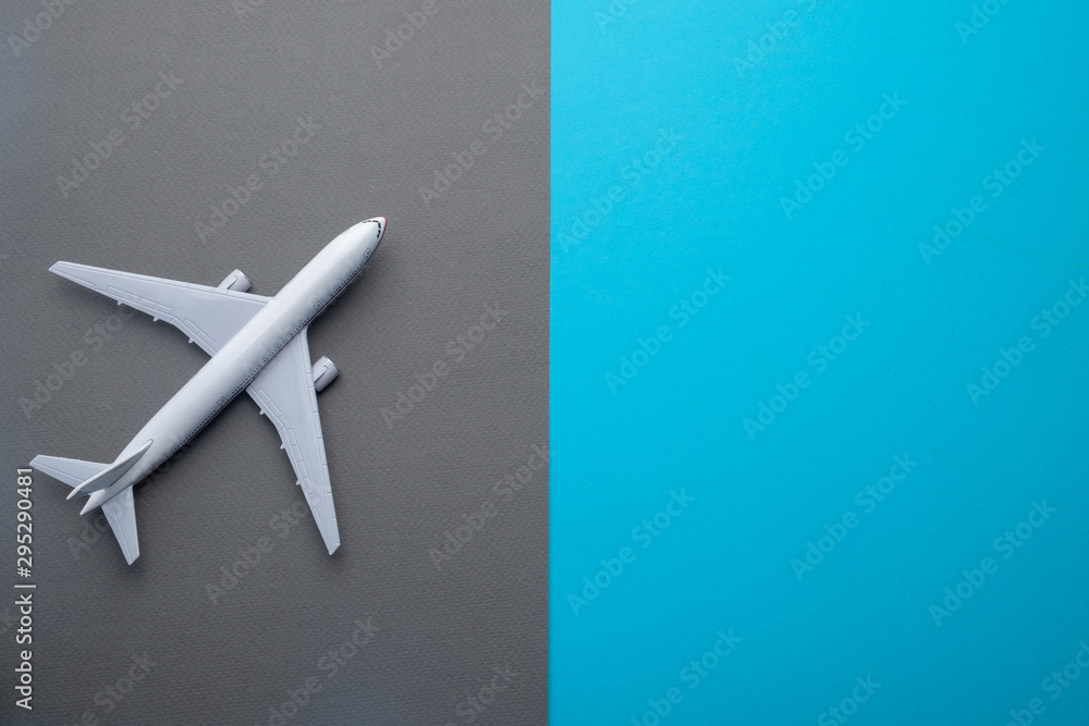 Flat lay airplane on grey and blue background