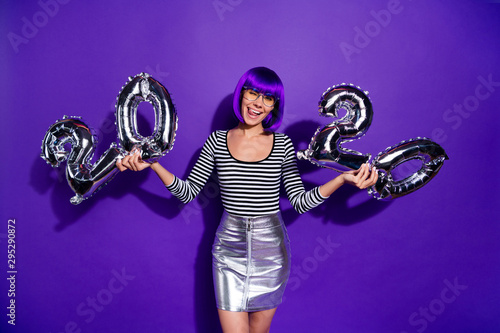 Photo of funny lady hold hands ballons new year party wear specs skirt striped pullover isolated purple background